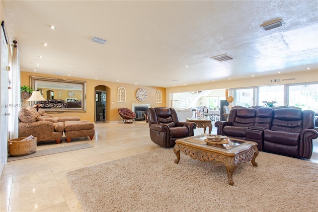 living room featuring a textured ceiling and light tile flooring