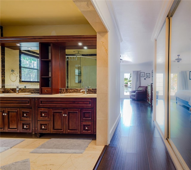 bathroom with double sink vanity, ornamental molding, and ceiling fan