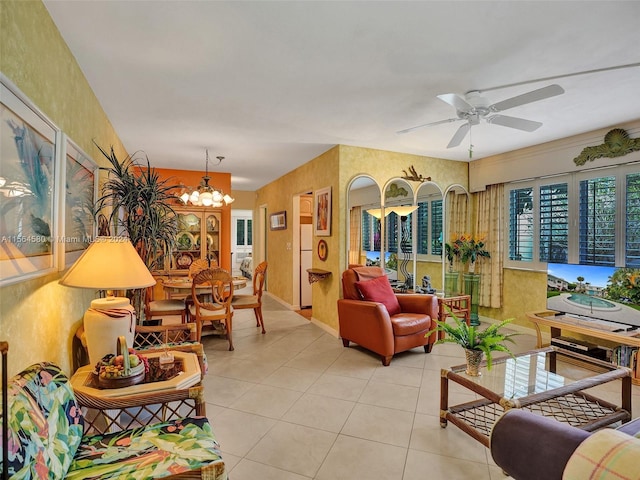 tiled living room with ceiling fan with notable chandelier