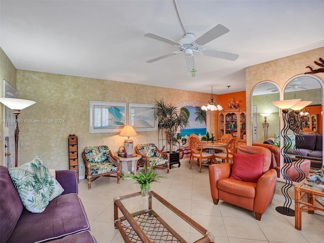 tiled living room with ceiling fan with notable chandelier