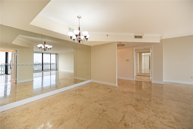 tiled spare room with a chandelier, a tray ceiling, and ornamental molding