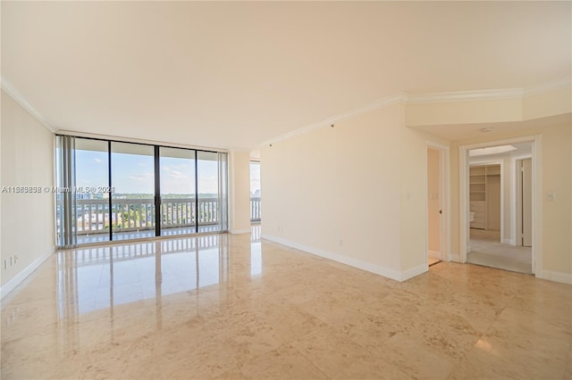 spare room featuring light tile floors, expansive windows, and ornamental molding