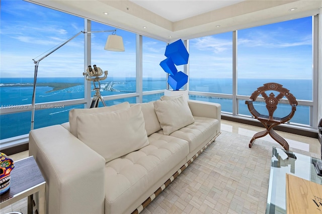 sunroom featuring a water view