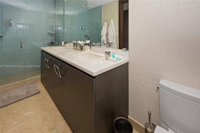 bathroom with toilet, tile floors, a shower with shower door, and dual vanity