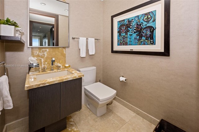 bathroom with vanity, tile floors, tasteful backsplash, and toilet