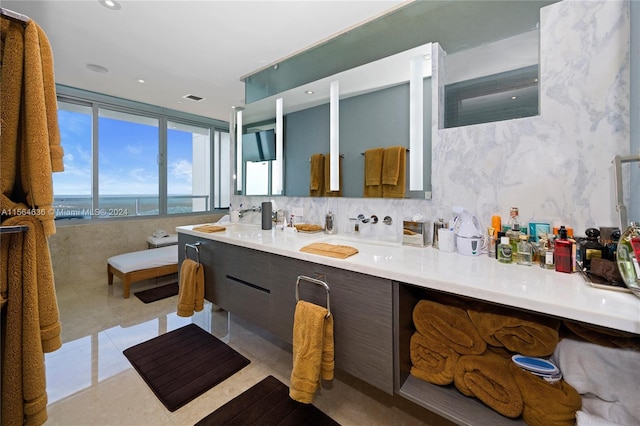 bathroom featuring dual bowl vanity, tile flooring, tasteful backsplash, and expansive windows