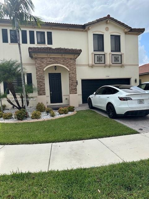 mediterranean / spanish-style home with a front lawn and a garage