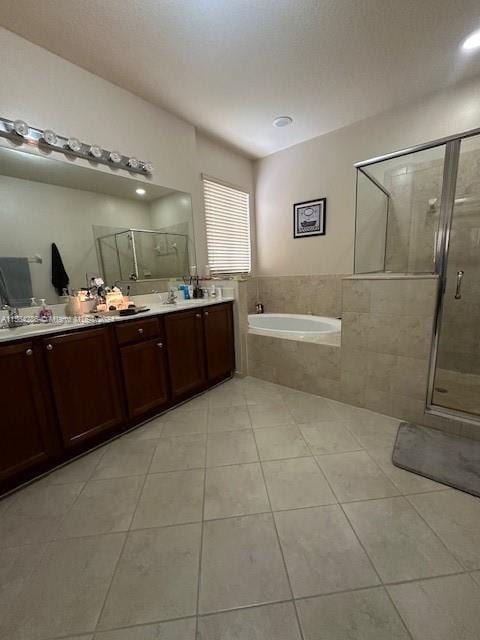 bathroom with plus walk in shower, dual sinks, vanity with extensive cabinet space, and tile flooring