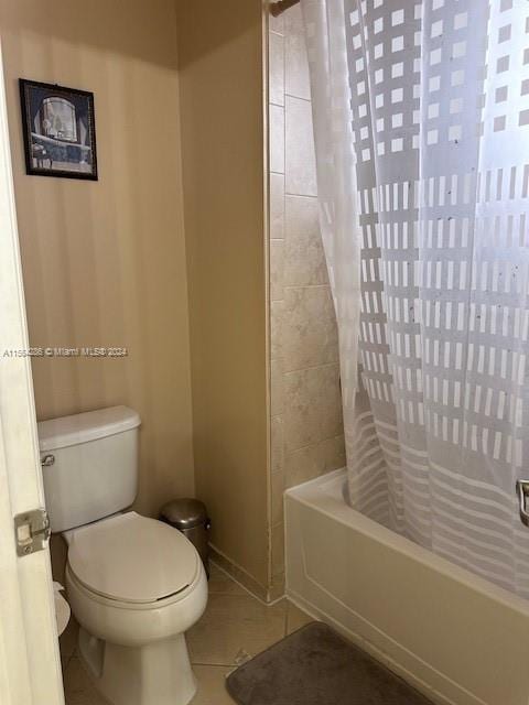 bathroom featuring tile flooring, shower / bath combination with curtain, and toilet