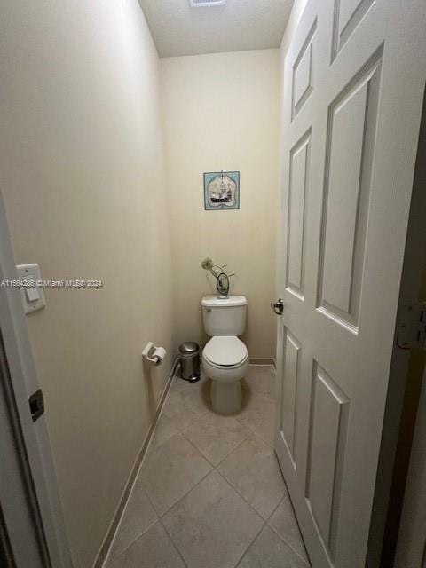 bathroom with tile flooring and toilet