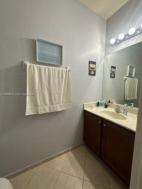 bathroom with toilet, tile flooring, and vanity