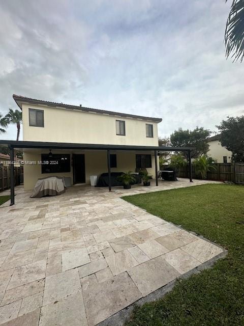 rear view of property featuring a pergola, a patio area, and a yard