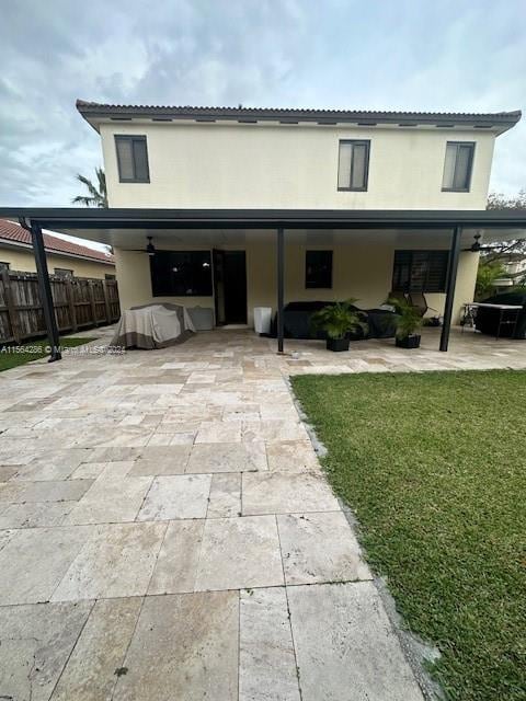 rear view of property with a lawn and a patio