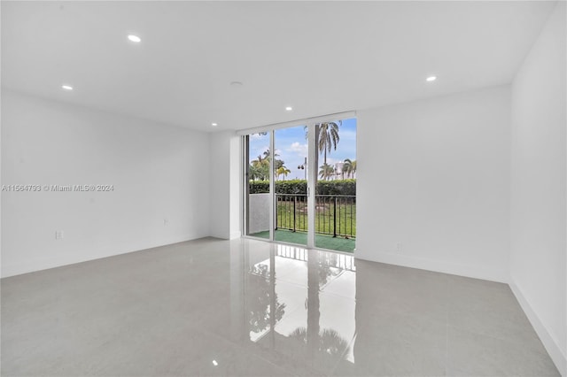 unfurnished room featuring a wall of windows