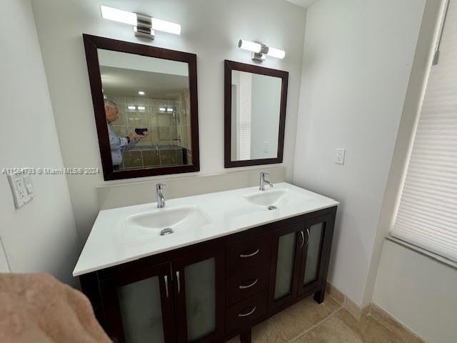 bathroom with tile flooring and double vanity