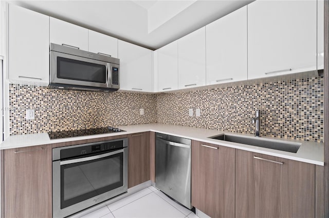 kitchen with stainless steel appliances, backsplash, white cabinets, and sink