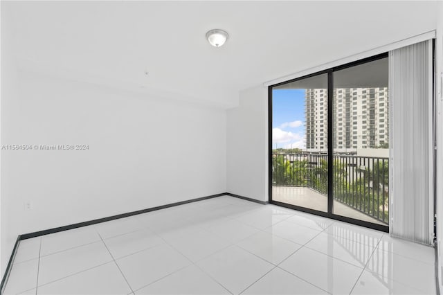 unfurnished room featuring expansive windows and light tile patterned flooring