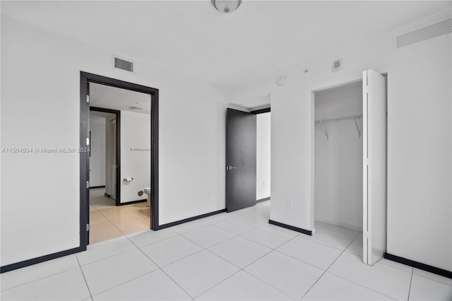 unfurnished bedroom featuring light tile patterned floors and a closet