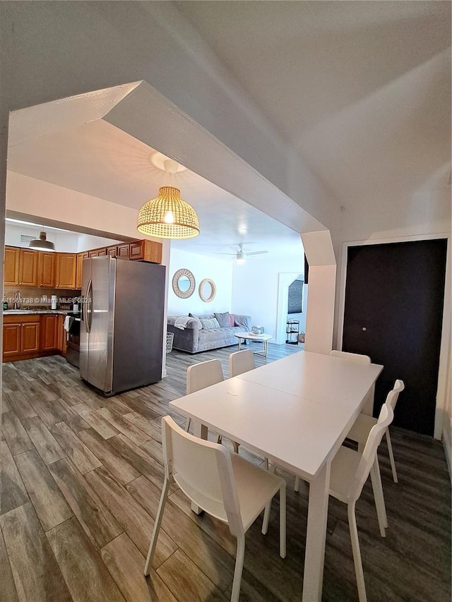 dining room featuring ceiling fan, sink, and wood-type flooring