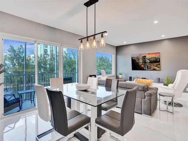 dining space featuring light tile flooring, a healthy amount of sunlight, and an inviting chandelier