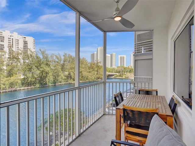 balcony with a water view and ceiling fan