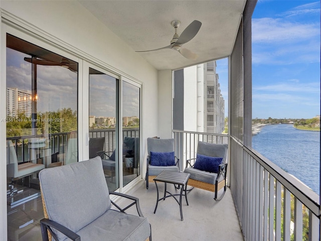 sunroom / solarium with a water view and ceiling fan