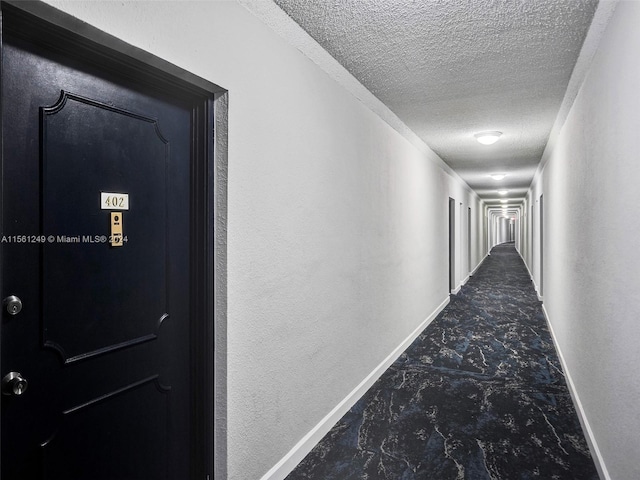 hall with tile flooring and a textured ceiling