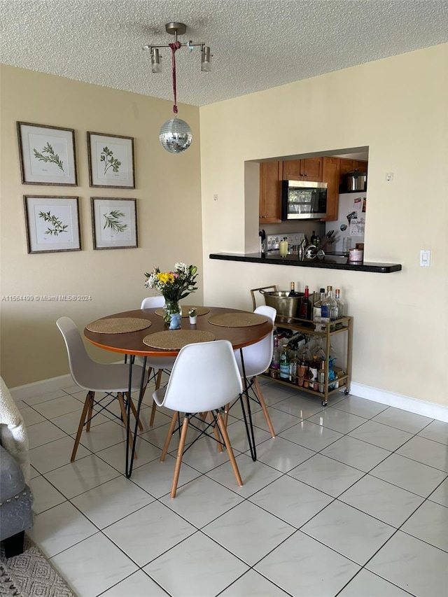 tiled dining space with a textured ceiling