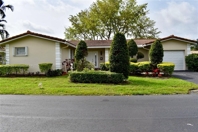 ranch-style home with a garage and a front lawn