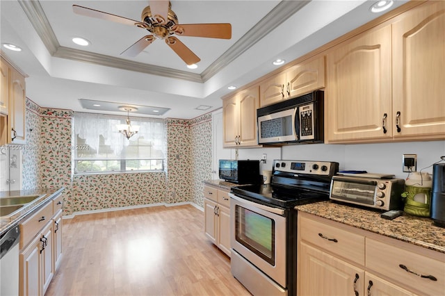 kitchen with a raised ceiling, light wood-type flooring, light brown cabinetry, appliances with stainless steel finishes, and ornamental molding