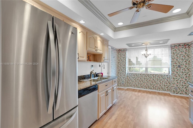 kitchen featuring dark stone counters, crown molding, sink, light hardwood / wood-style floors, and stainless steel appliances