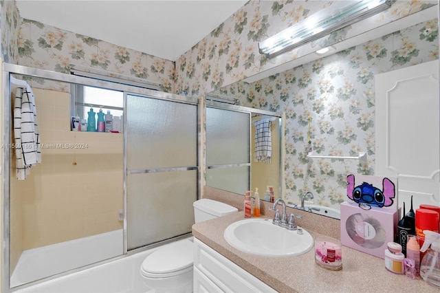 full bathroom featuring shower / bath combination with glass door, vanity, and toilet