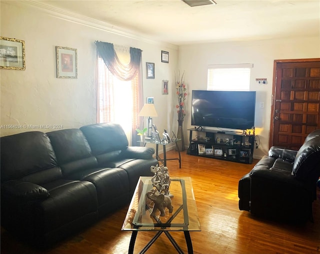 living room with wood-type flooring and ornamental molding