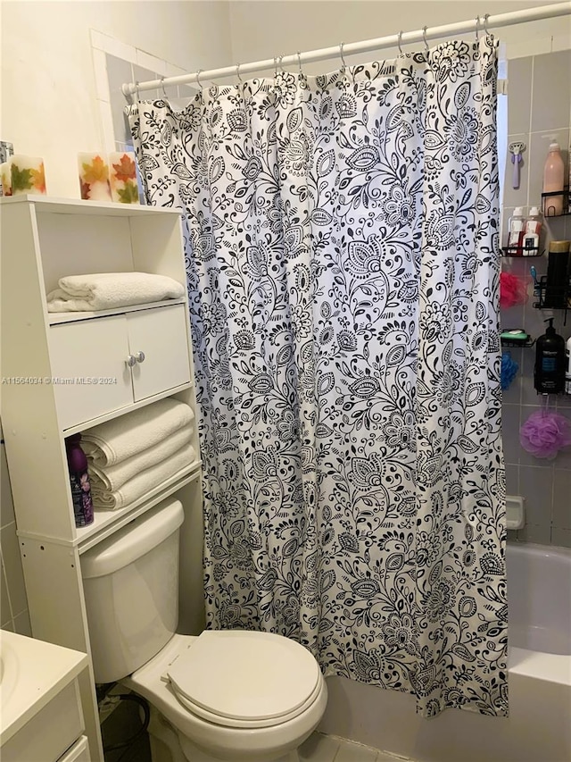 full bathroom featuring tile patterned floors, shower / bath combo with shower curtain, vanity, and toilet