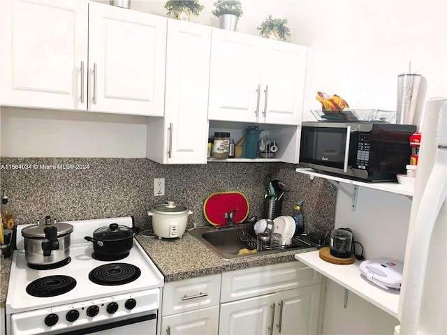 kitchen featuring white appliances, tasteful backsplash, and white cabinetry