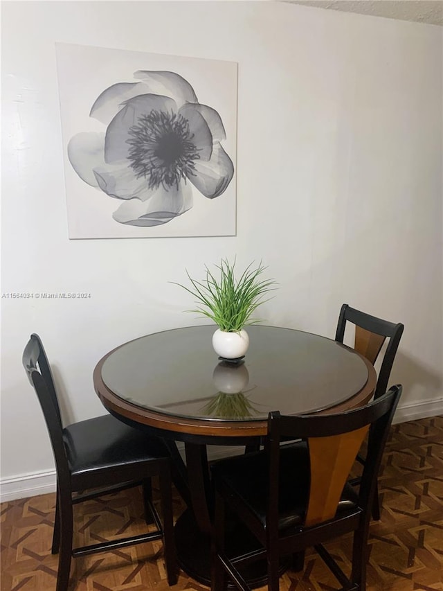 dining space with dark parquet flooring