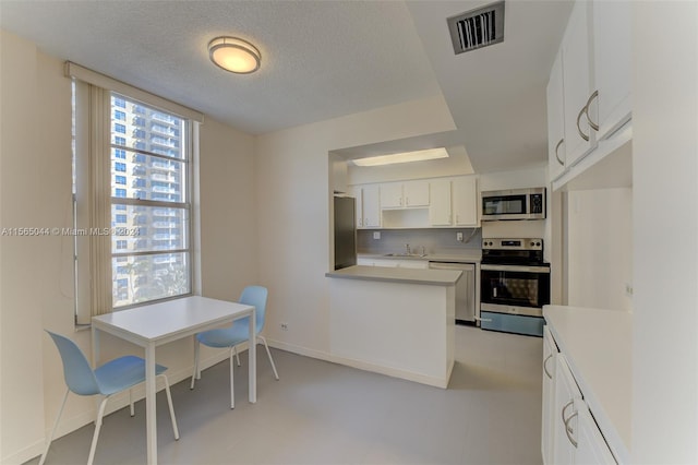 kitchen with sink, light tile floors, white cabinets, backsplash, and stainless steel appliances