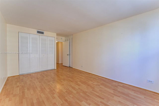 unfurnished bedroom with a closet and light hardwood / wood-style flooring