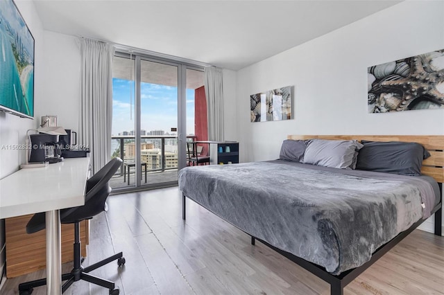 bedroom with light hardwood / wood-style flooring, access to exterior, and expansive windows