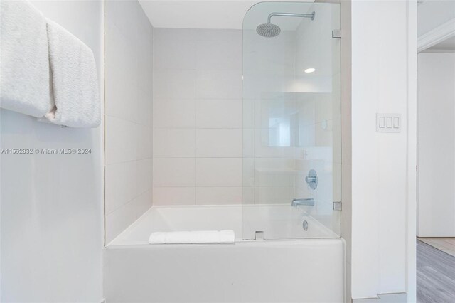 bathroom with tiled shower / bath and wood-type flooring