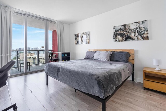 bedroom featuring floor to ceiling windows, light wood-type flooring, and access to exterior