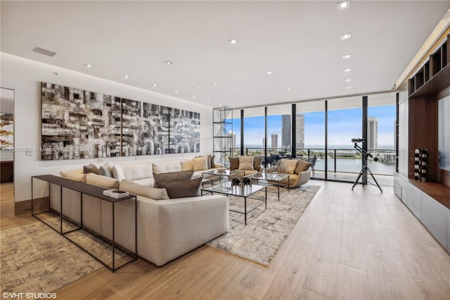 living room with floor to ceiling windows and light hardwood / wood-style floors