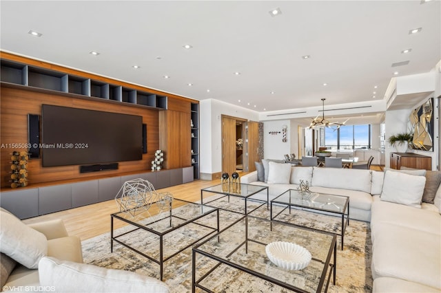 living room with light hardwood / wood-style flooring and a chandelier