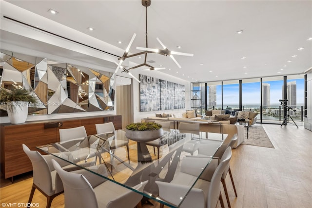 dining area featuring light hardwood / wood-style floors, ceiling fan, and expansive windows