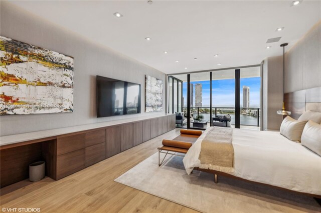 bedroom featuring floor to ceiling windows, light hardwood / wood-style floors, and access to outside