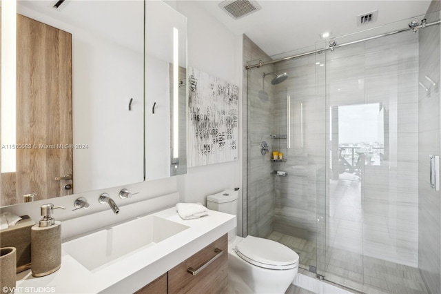 bathroom with a shower with shower door, vanity, and toilet