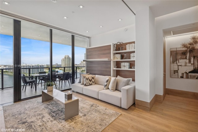 living room featuring a water view, light hardwood / wood-style flooring, and expansive windows