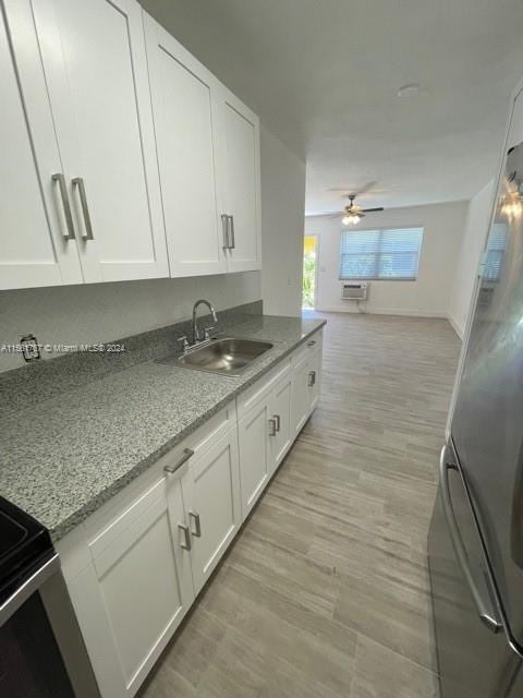 kitchen featuring white cabinets, ceiling fan, and light hardwood / wood-style flooring