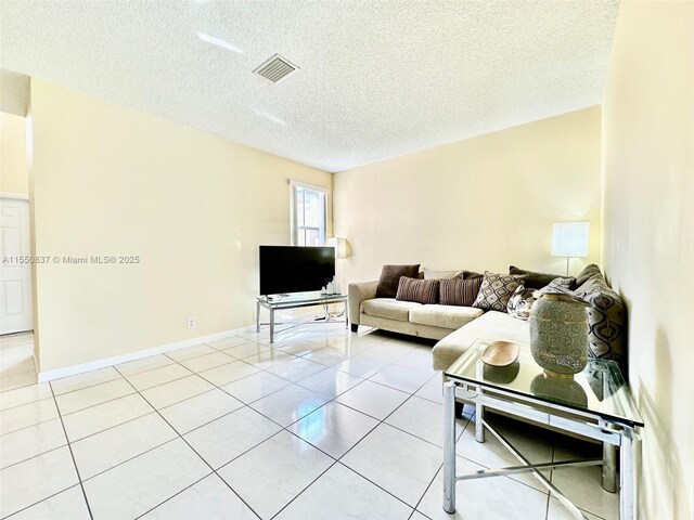 tiled living room featuring a textured ceiling