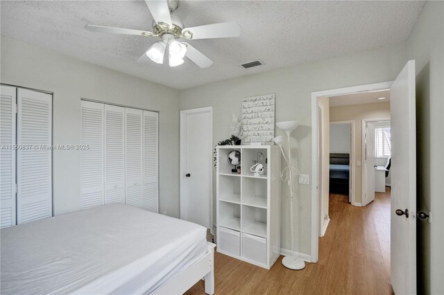 bedroom featuring hardwood / wood-style flooring, a closet, ceiling fan, and a textured ceiling